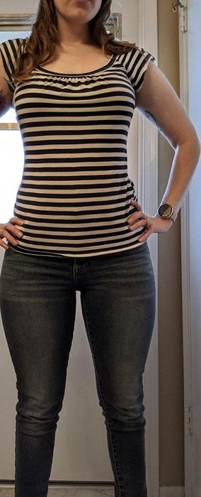 A reviewer confidently posing in dark wash jeans.