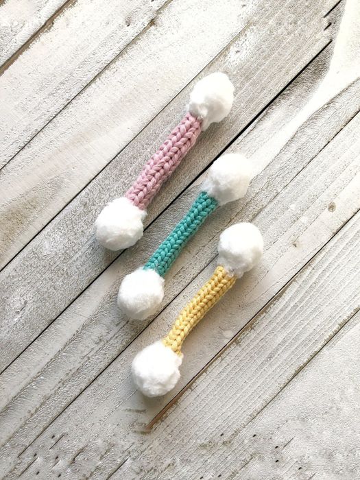 The cotton swab-shaped toy comes in vibrant pink, green, and yellow colors