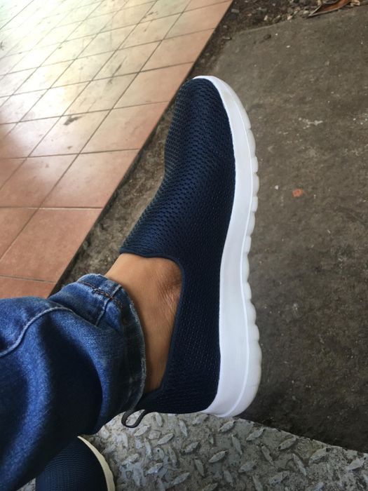 A reviewer wearing the black walking shoes with white soles