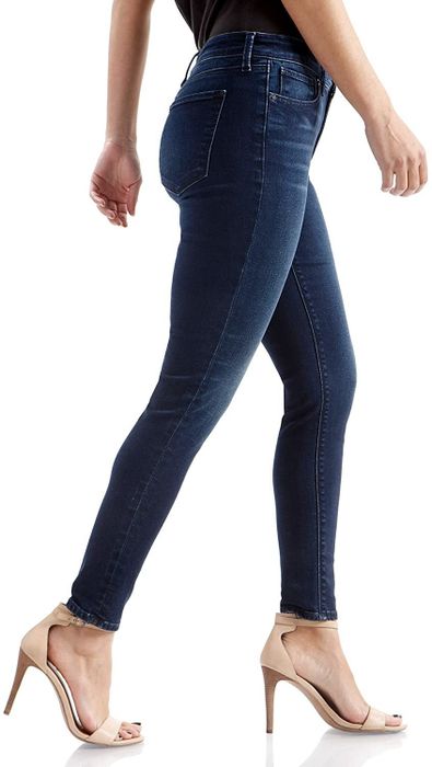 A model walking with confidence in indigo wash jeans while rocking high heels.