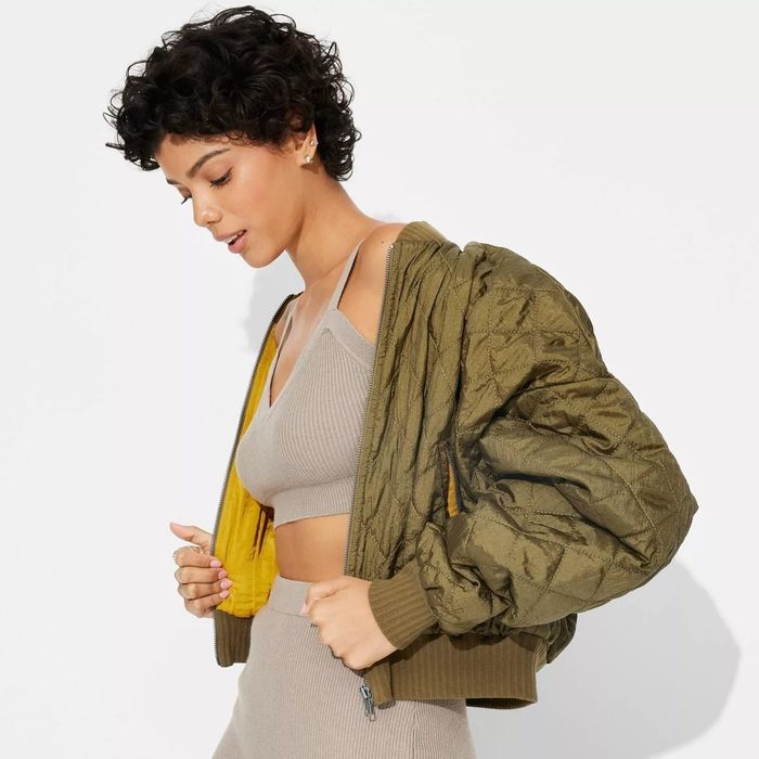 A model showcasing a quilted jacket paired with a coordinated ribbed crop top and skirt.