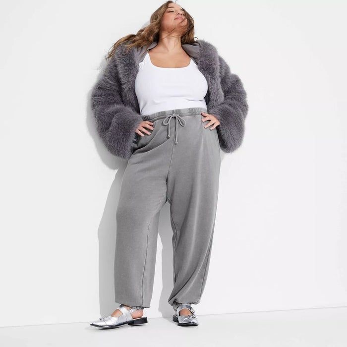 A model showcasing a cozy coat, tank top, and loose-fitting pants.