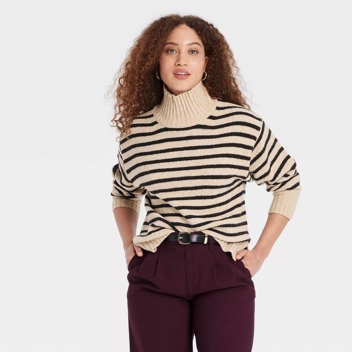 A model sporting a striped turtleneck sweater paired with dark pants.