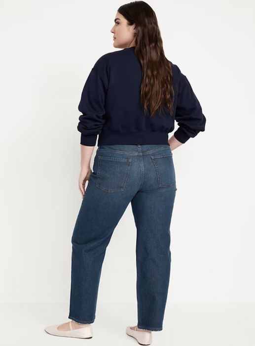 A person wearing casual jeans and a dark sweater, viewed from behind.