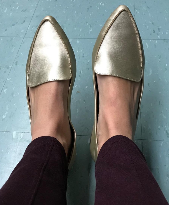 A reviewer wearing the gold loafers