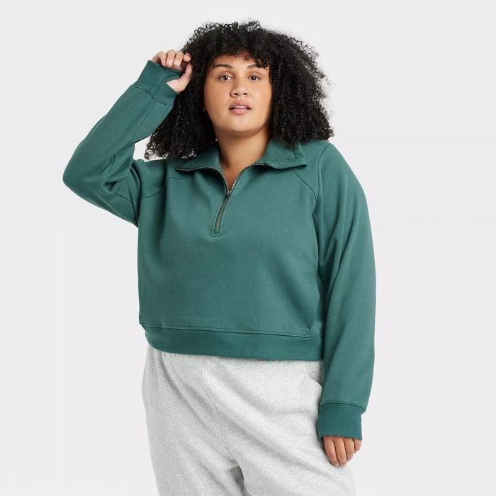 A model is wearing a zip-neck pullover sweatshirt paired with cozy gray sweatpants.
