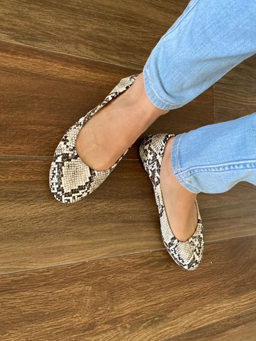 A reviewer wearing the black and white patterned flats