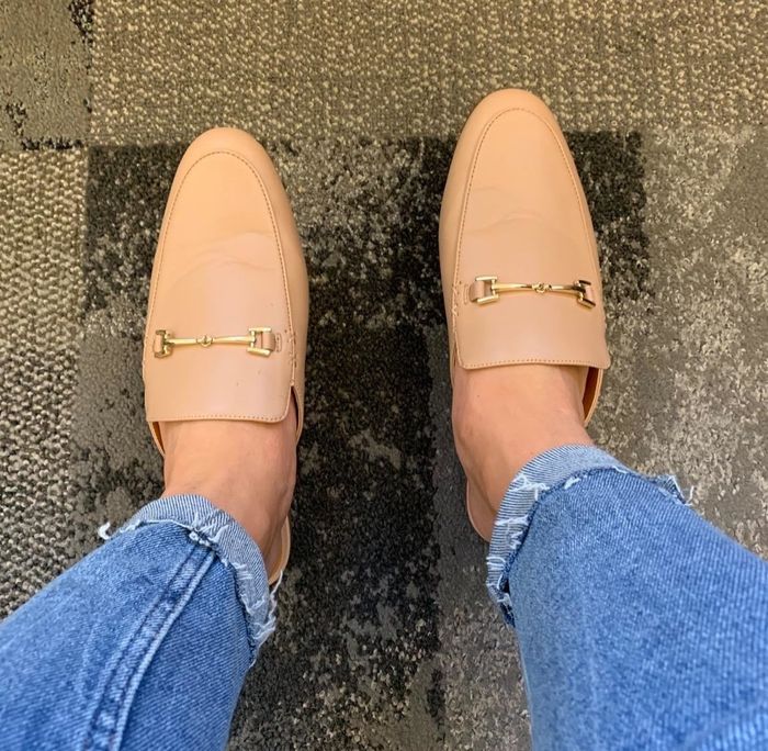 reviewer wearing tan buckle-detail loafer mules