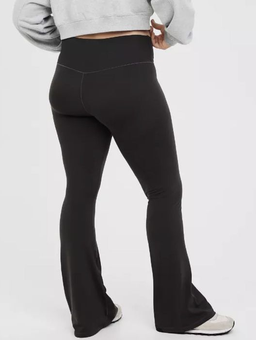 A model photographed from behind, wearing black leggings.