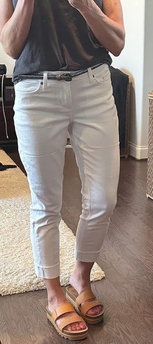 A reviewer showcasing white jeans paired with sandals.