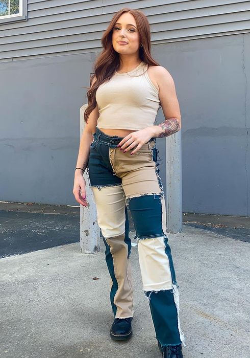 A reviewer wearing the blue-and-white patchwork jeans.