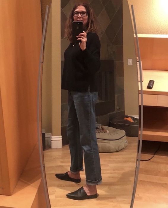 A reviewer’s selfie showing off the relaxed-fit jeans cuffed at the ankles.