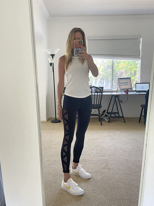 A reviewer wearing black leggings with zigzag-patterned mesh panels on the sides.