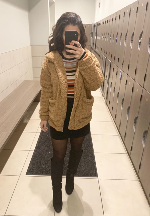 reviewer styling the brown teddy coat with a skirt and tights