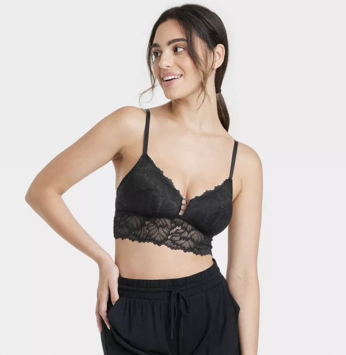 A model showcasing a black longline lace bralette