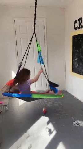 A reviewer’s kids having fun swinging indoors.