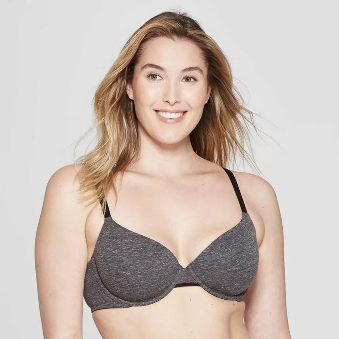 A model smiling while wearing a gray bra