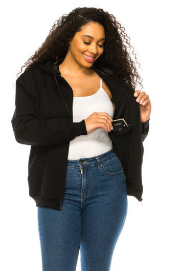 a model wearing the black zip-up, highlighting the hidden internal pockets