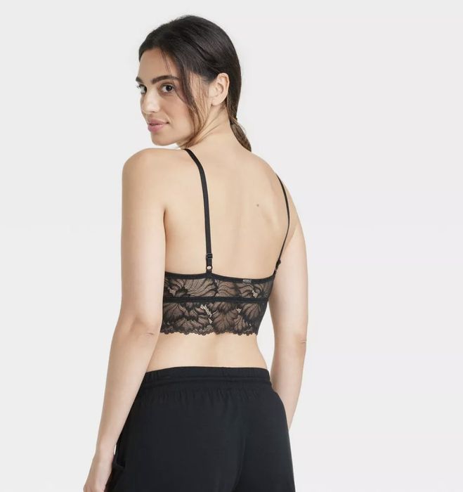 A model wearing a black lace longline bralette, viewed from the back