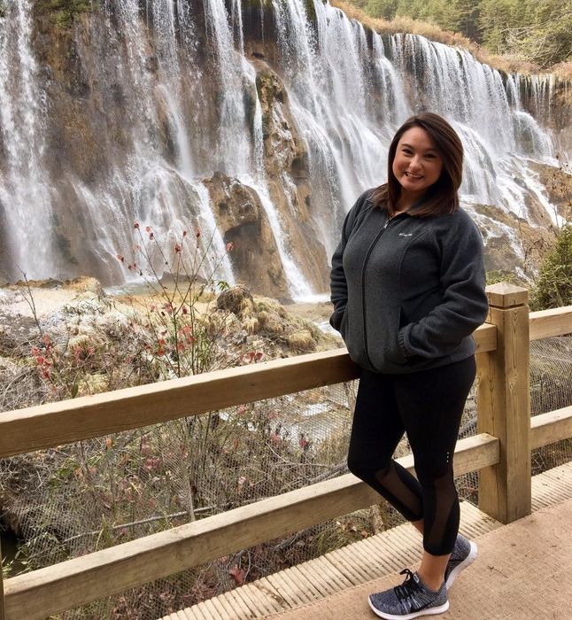 reviewer modeling the charcoal waist-length jacket with a zipper