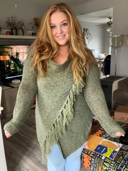 reviewer sporting a snug knit sweater featuring fringe embellishments