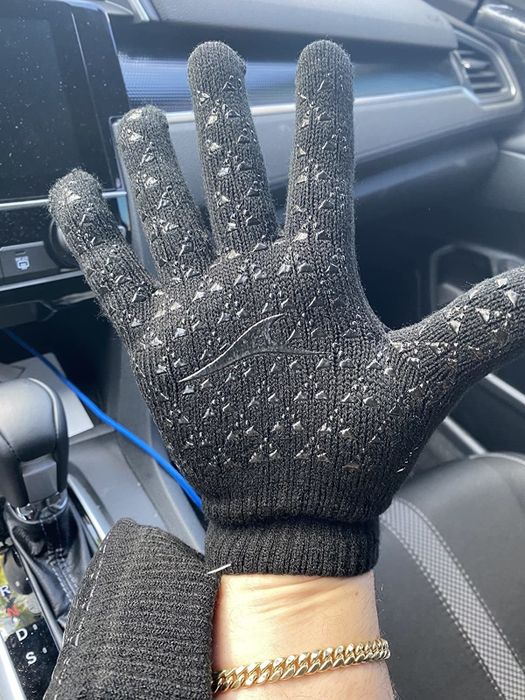 Reviewer wearing black gloves with a glossy black texture and pattern