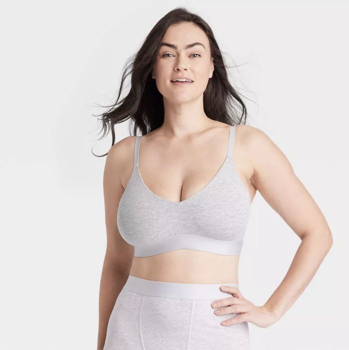 A model posing in a casual light gray triangle bralette