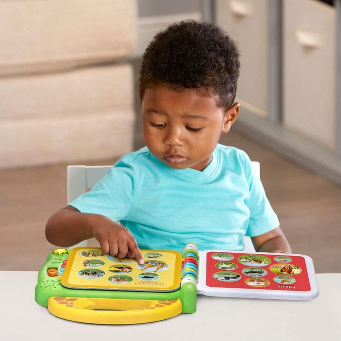 A child pressing a button on the LeapFrog 100 Animals book.