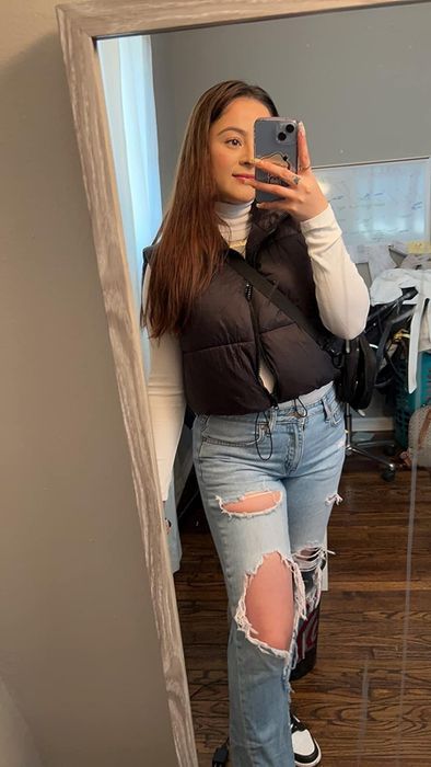 reviewer showcasing a black puffer vest