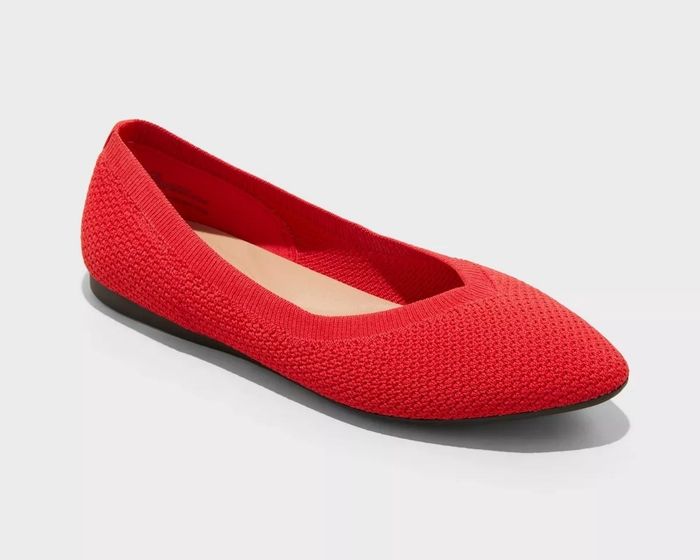 Single red ballet flat shoe featuring a woven texture set against a plain background