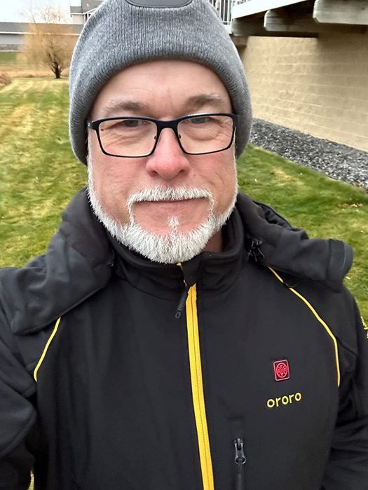 a reviewer modeling the black coat featuring yellow accents
