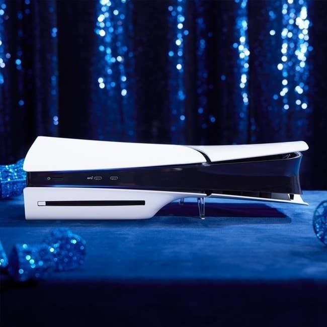 A gaming console sitting on a table, surrounded by a shimmering background, showcased in an article about top shopping picks.