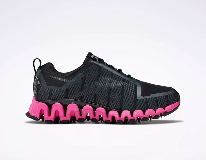 A black sneaker featuring a vibrant pink sole.