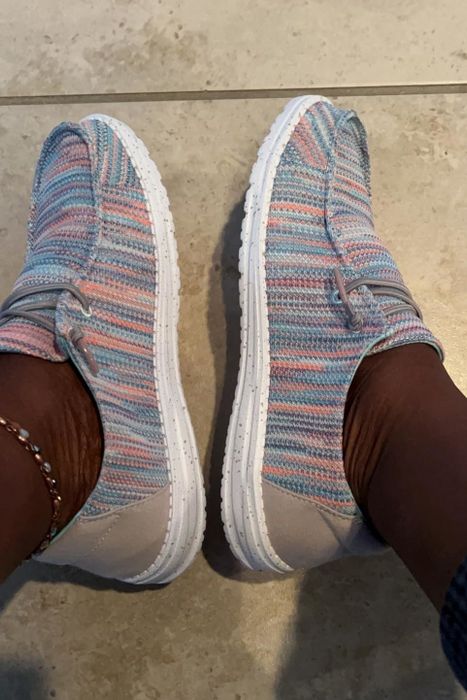 Reviewer wearing multicolored patterned loafers with gray speckled soles.