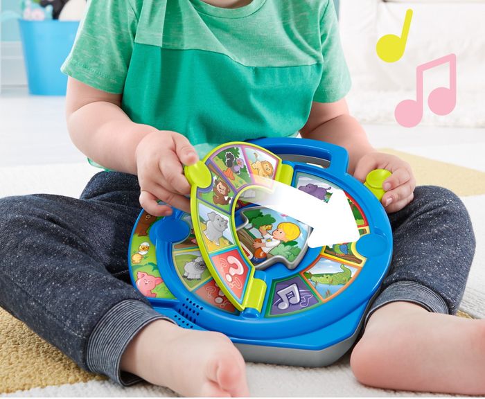 A child enjoys playing with an interactive toy that features animal sounds. Text on the toy reads: 