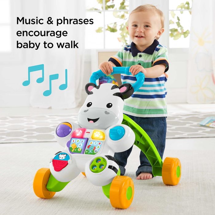 A toddler joyfully pushing a zebra-themed walker across the floor.