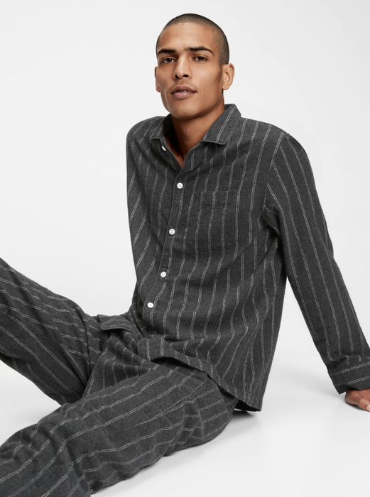 A model posing in a stylish pinstripe pajama set.