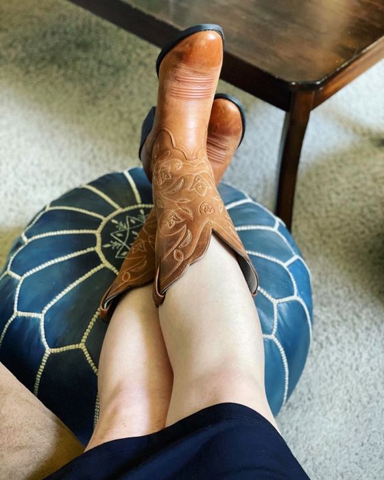 Reviewer wearing brown embroidered boots.