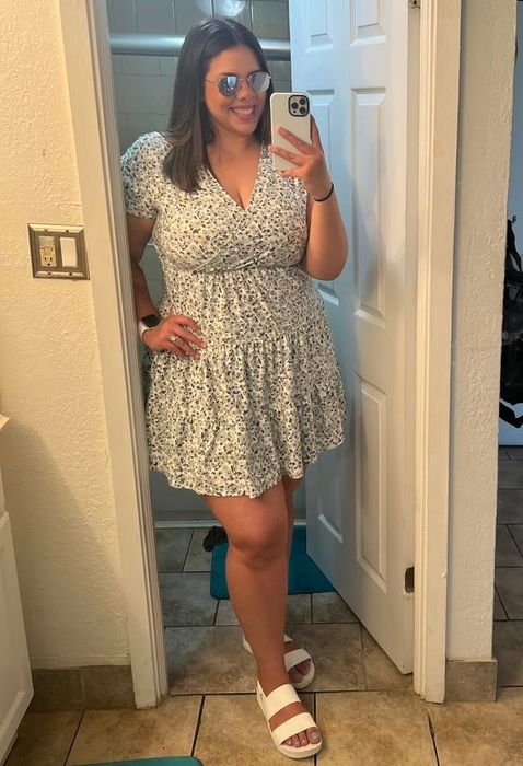 Reviewer wearing white sandals paired with a floral dress.