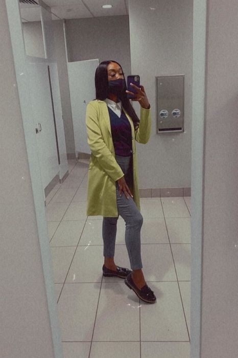 Reviewer taking a mirror selfie while wearing the loafers with a light jacket, purple top, and grey pants.