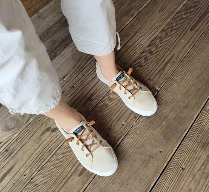 A reviewer pairs the canvas sneakers, featuring leather laces in beige with a white rubber outsole, with a laid-back outfit.