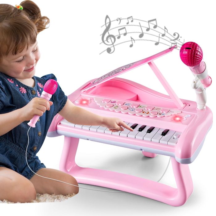 A child happily playing a pink toy piano with a microphone, beaming with joy, while musical notes float above the piano