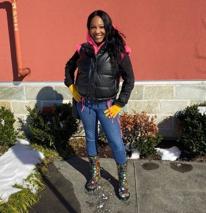 Reviewer wearing dark floral patterned boots with skinny jeans and a puffer vest.