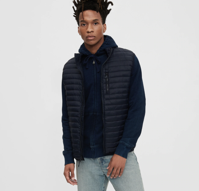 Model showcasing a puffer vest in classic true black.