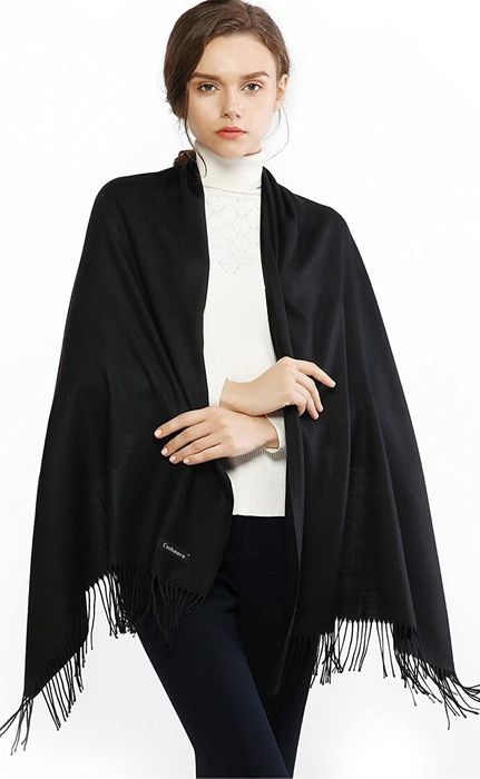 Model demonstrating a scarf styled as a poncho