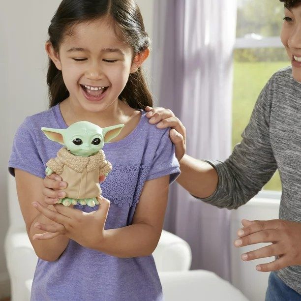 Two kids having fun playing with the Baby Yoda Bop It game.