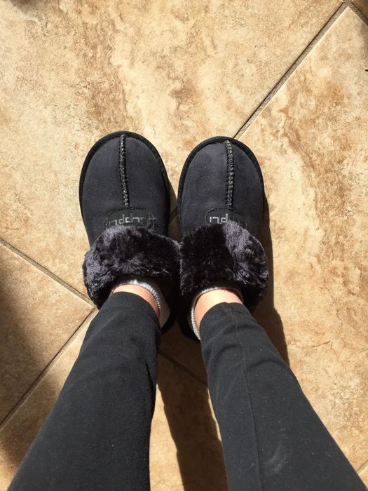Reviewer displaying the top of black slippers