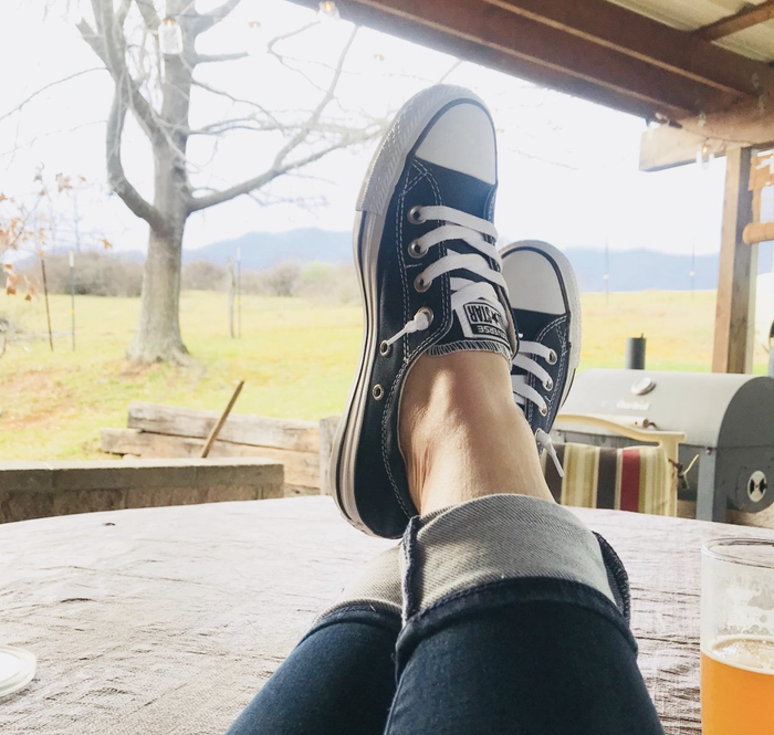 Reviewer wearing black slip-on Converse sneakers