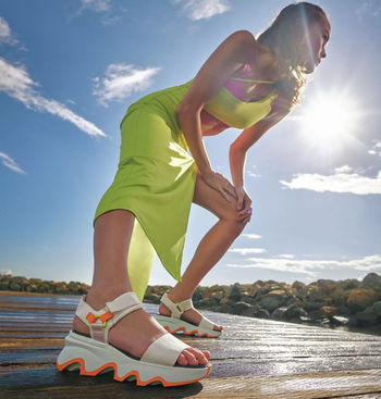 a model showcasing the sandals in white and orange