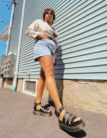 A model showcasing the sleek black gladiator sandals